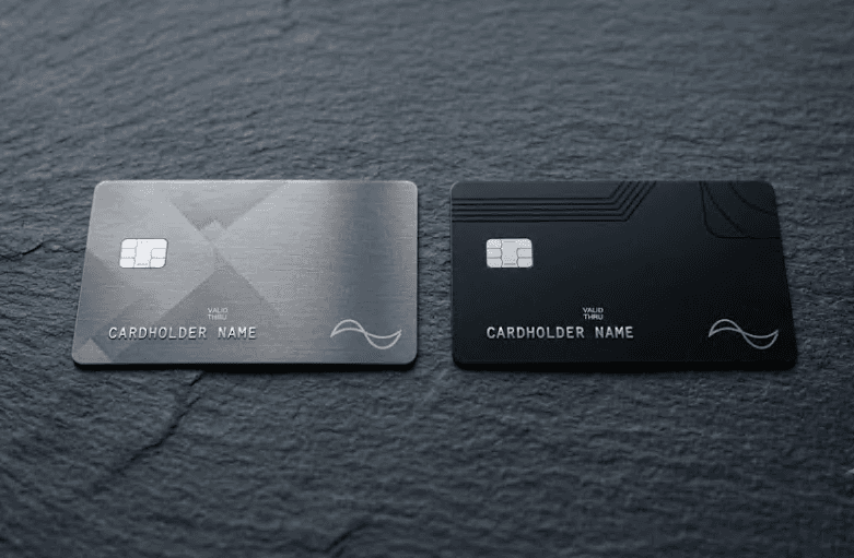 Two payment cards lying side by side on a dark surface.